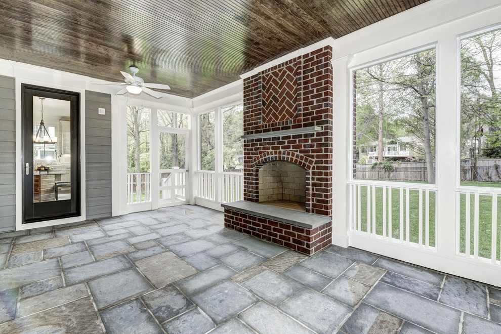 Идея дизайна: большая веранда на заднем дворе в классическом стиле с местом для костра, покрытием из каменной брусчатки и навесом