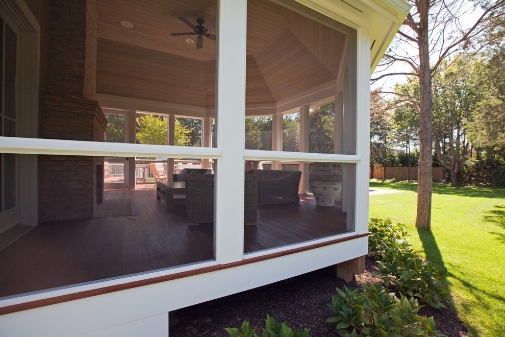 Cette photo montre un grand porche d'entrée de maison arrière chic avec une moustiquaire.