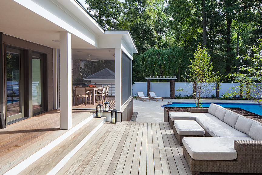 Réalisation d'un porche d'entrée de maison design avec une moustiquaire, une terrasse en bois et une extension de toiture.