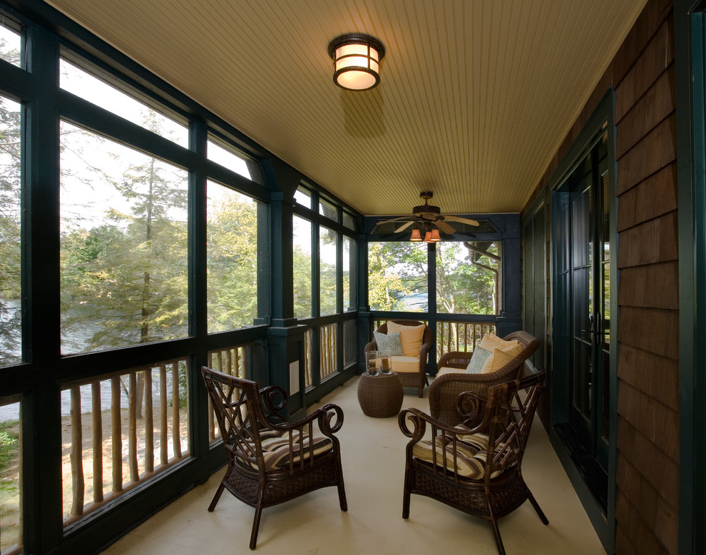 This is an example of a large rustic screened-in back porch design in New York with a roof extension.