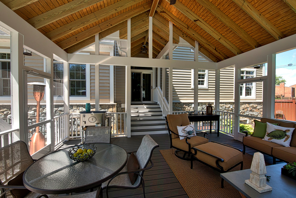Idée de décoration pour un grand porche d'entrée de maison arrière tradition avec une moustiquaire, des pavés en pierre naturelle et une extension de toiture.