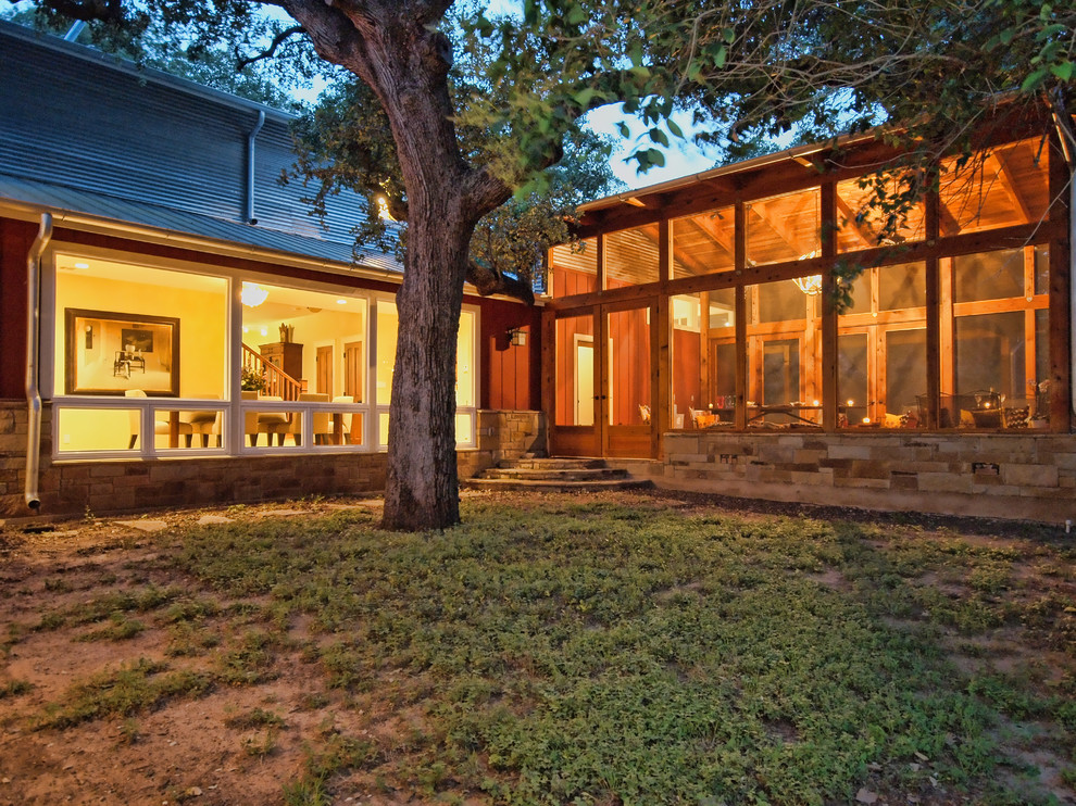 This is an example of a mid-sized country side porch design in Austin with a fire pit and a roof extension.