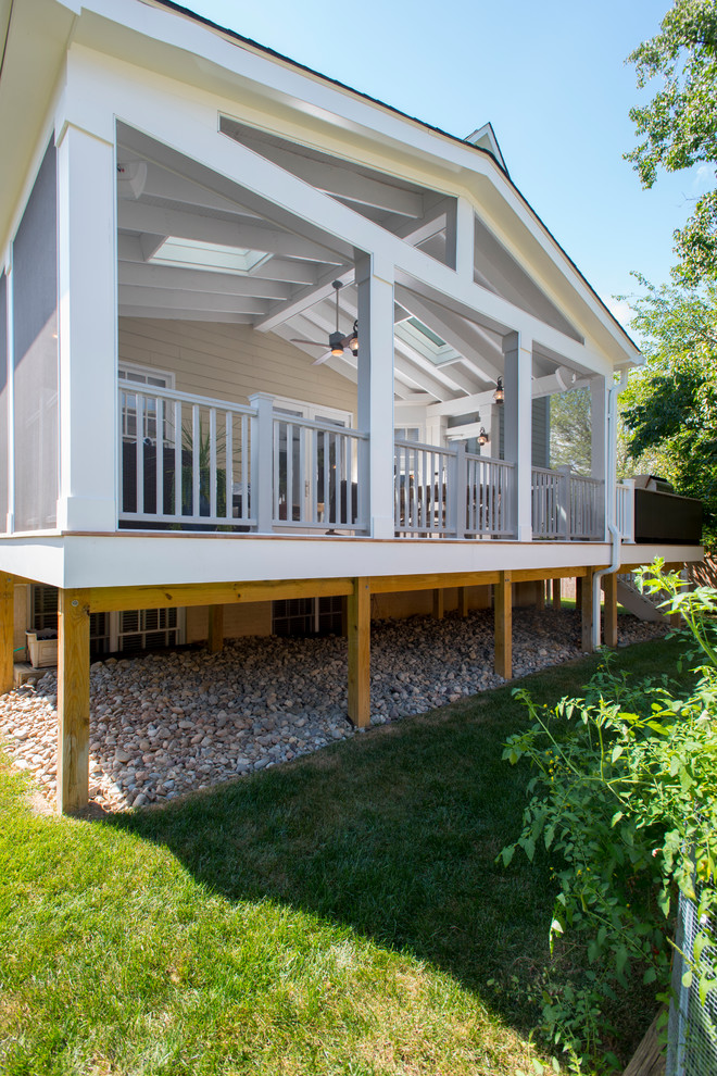 Idées déco pour un grand porche d'entrée de maison arrière classique avec une moustiquaire, une terrasse en bois et une extension de toiture.