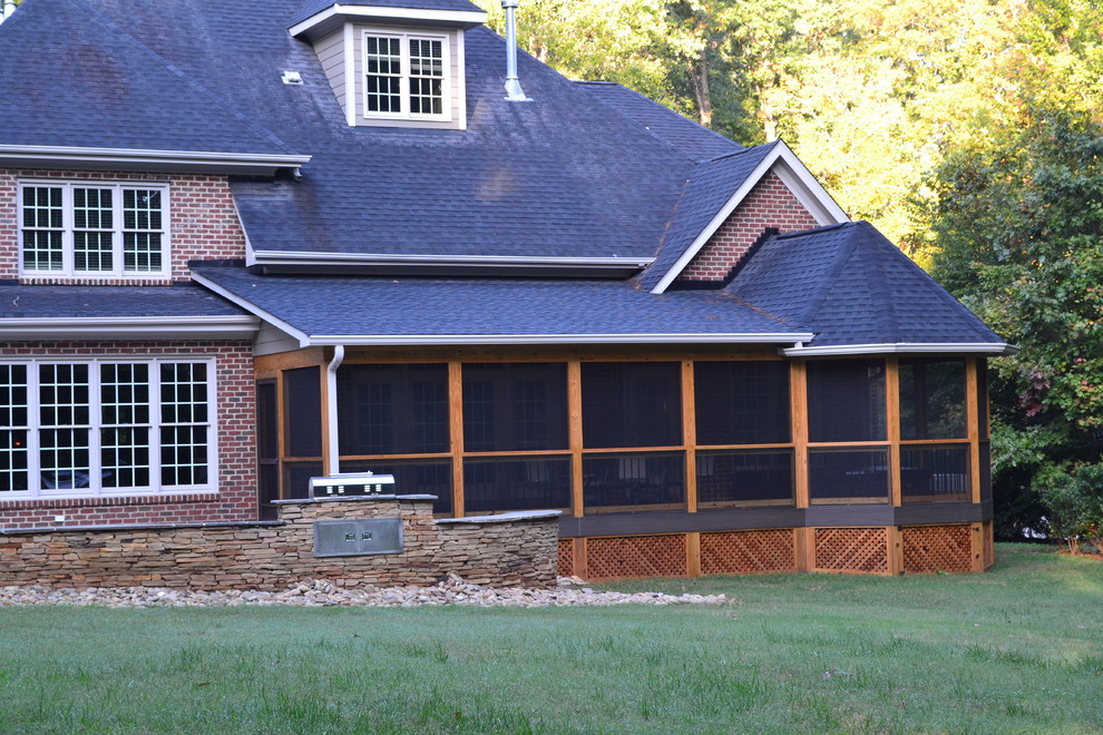Large elegant stone screened-in back porch photo in Raleigh with a roof extension