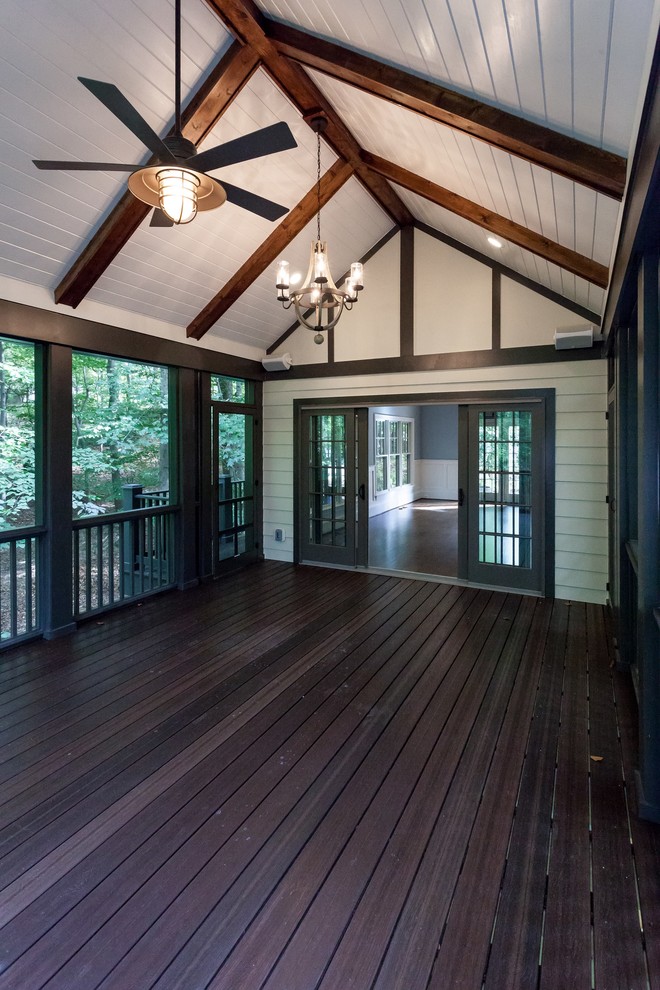 This is an example of a traditional screened-in back porch design in DC Metro with decking and a roof extension.