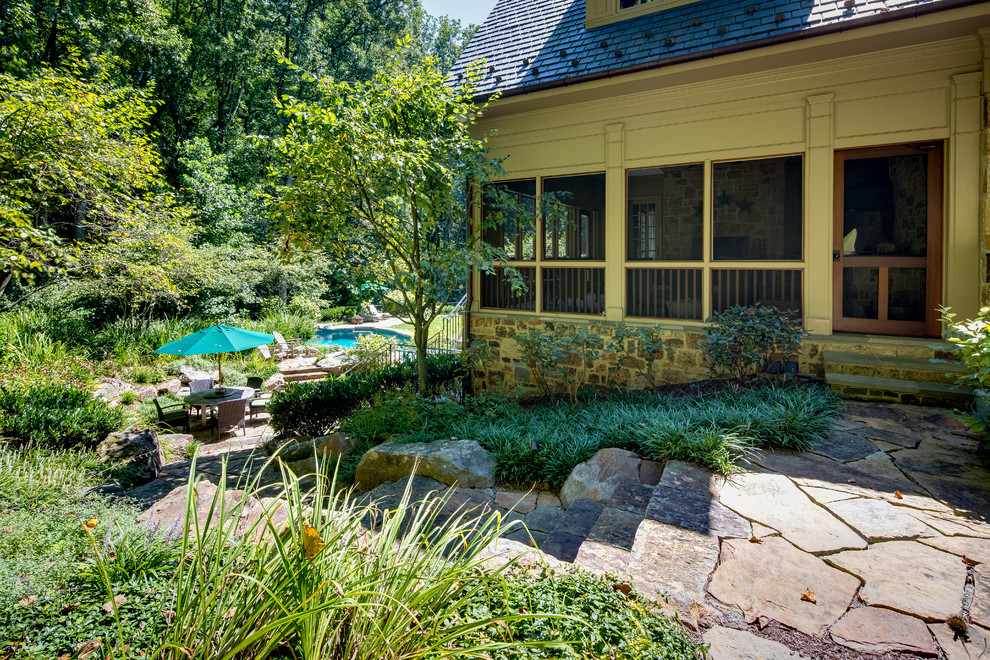 Cette photo montre un très grand porche d'entrée de maison arrière nature avec une cuisine d'été, des pavés en pierre naturelle et une extension de toiture.