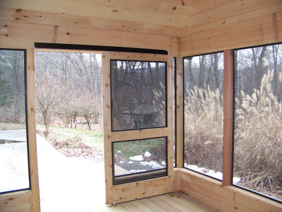 Aménagement d'un porche d'entrée de maison arrière craftsman de taille moyenne avec une moustiquaire, une terrasse en bois et une extension de toiture.