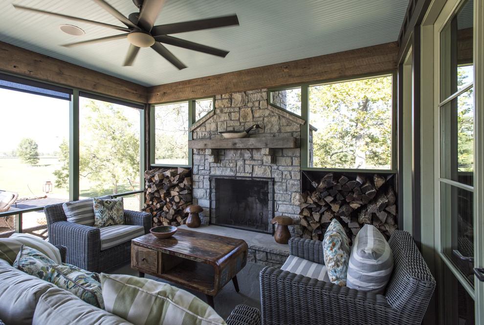 Large mountain style stone screened-in back porch idea in Louisville with a roof extension