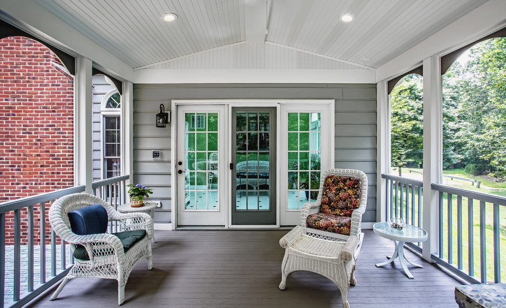 Mid-sized classic concrete paver screened-in back porch idea in DC Metro with a roof extension