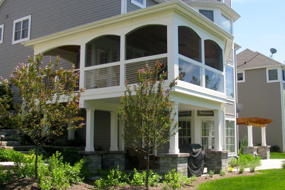 Imagen de porche cerrado minimalista grande en patio trasero y anexo de casas con adoquines de piedra natural