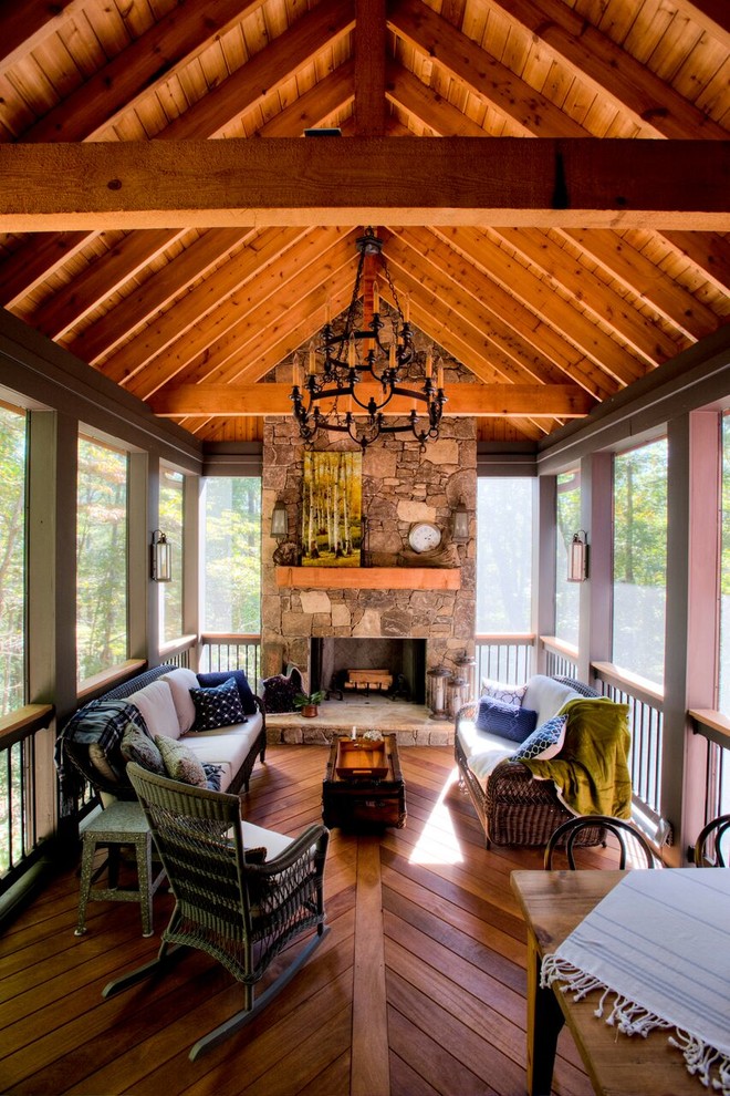 Cette photo montre un porche d'entrée de maison arrière craftsman de taille moyenne avec un foyer extérieur, une terrasse en bois et une extension de toiture.