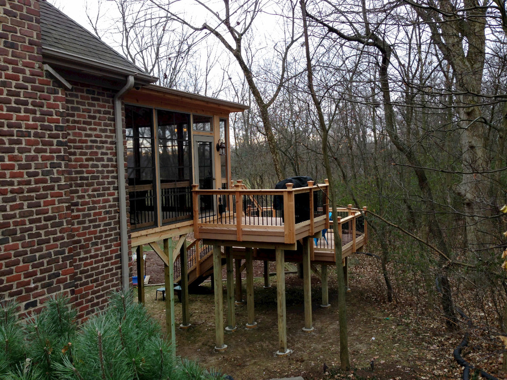 Cette photo montre un grand porche d'entrée de maison arrière montagne avec une moustiquaire, une terrasse en bois et une extension de toiture.