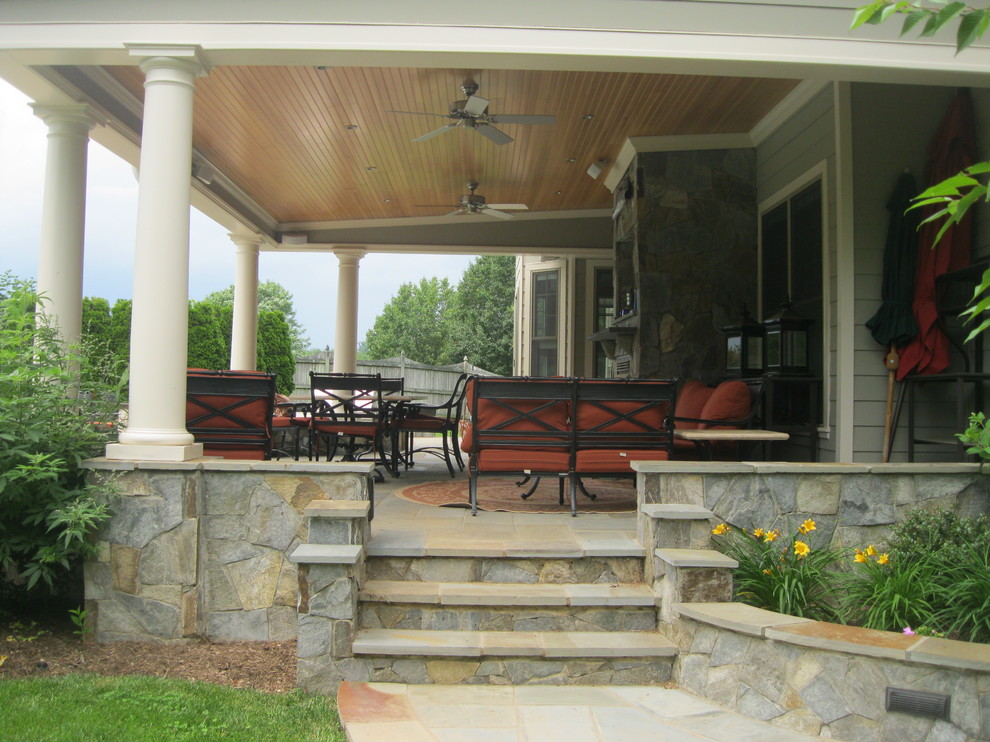 Réalisation d'un porche d'entrée de maison arrière tradition de taille moyenne avec des pavés en pierre naturelle et une extension de toiture.