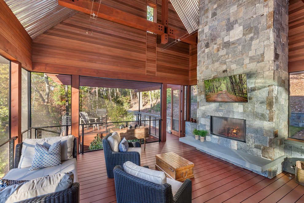 Idées déco pour un grand porche d'entrée de maison arrière montagne avec une moustiquaire, une terrasse en bois et une extension de toiture.