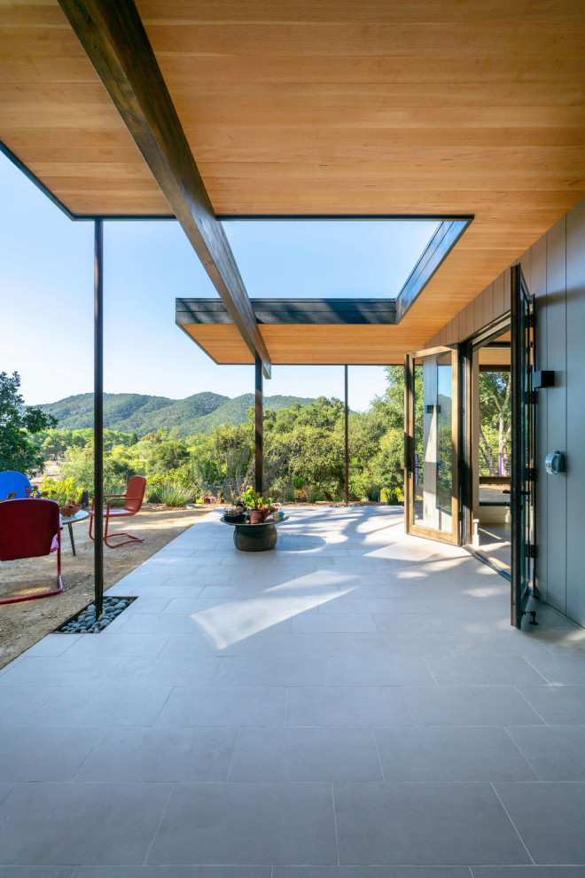 Exemple d'un porche d'entrée de maison avant rétro de taille moyenne avec du carrelage et une extension de toiture.