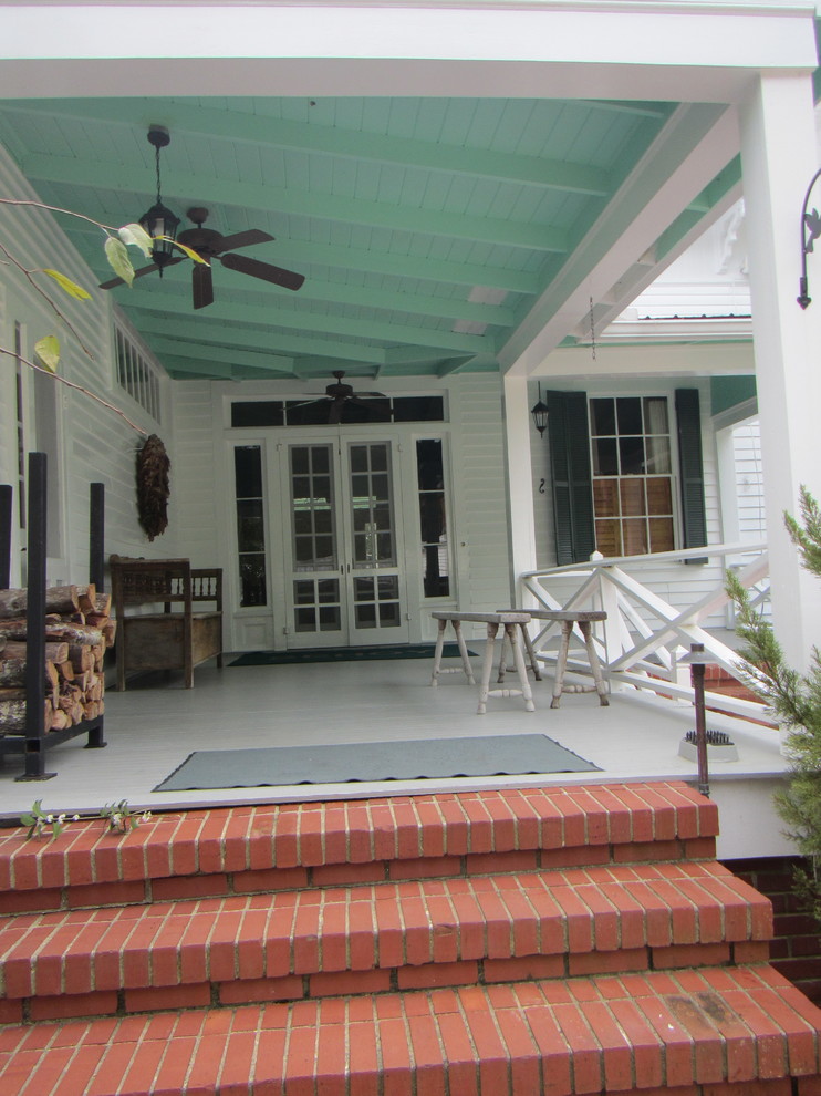 Réalisation d'un grand porche d'entrée de maison avant champêtre avec des pavés en brique et une extension de toiture.