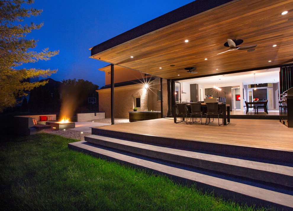 Idées déco pour un porche d'entrée de maison arrière moderne avec une terrasse en bois et une extension de toiture.