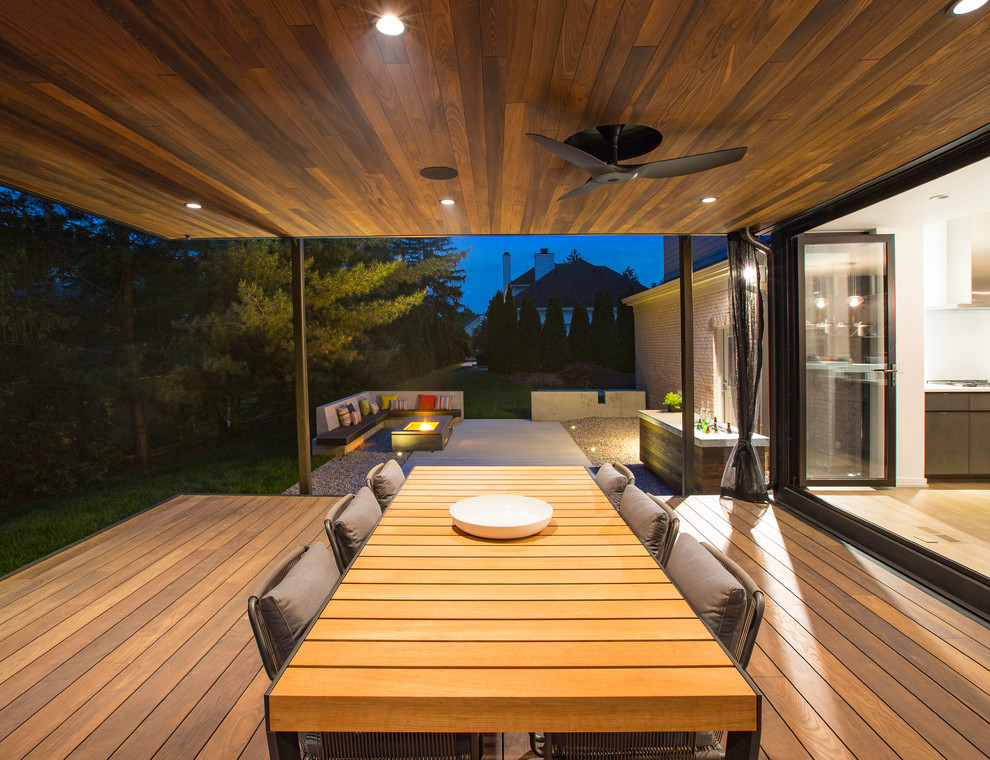 Foto di un portico moderno dietro casa con pedane e un tetto a sbalzo