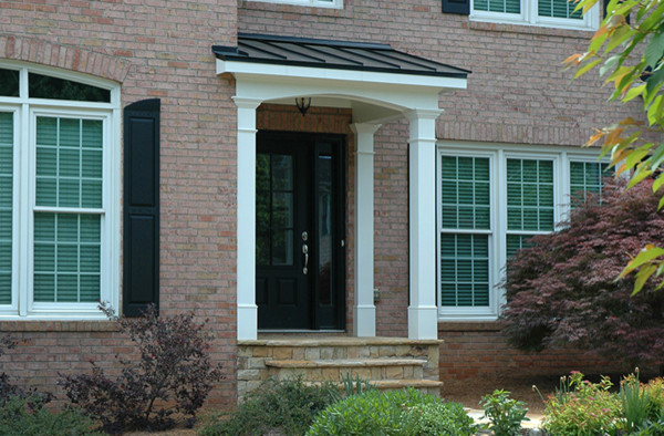 Cette photo montre un petit porche d'entrée de maison avant chic avec une extension de toiture.