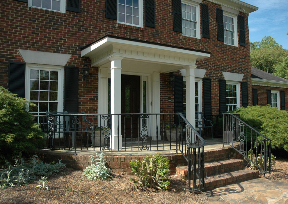 This is an example of a small traditional front porch design in Atlanta with a roof extension.