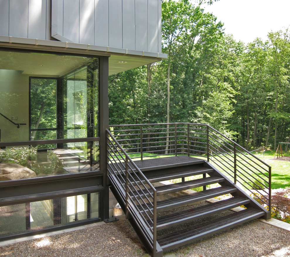 Réalisation d'un porche d'entrée de maison design avec une extension de toiture.