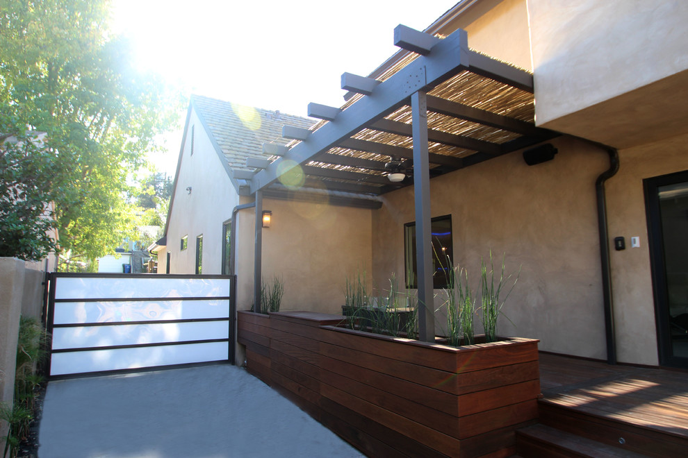Foto de terraza moderna de tamaño medio en patio trasero con jardín de macetas, entablado y pérgola