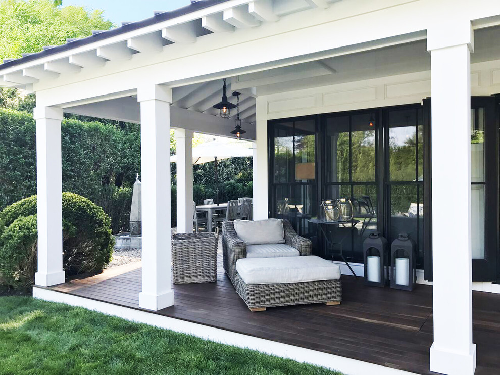Medium sized contemporary back veranda in New York with decking, a roof extension and feature lighting.