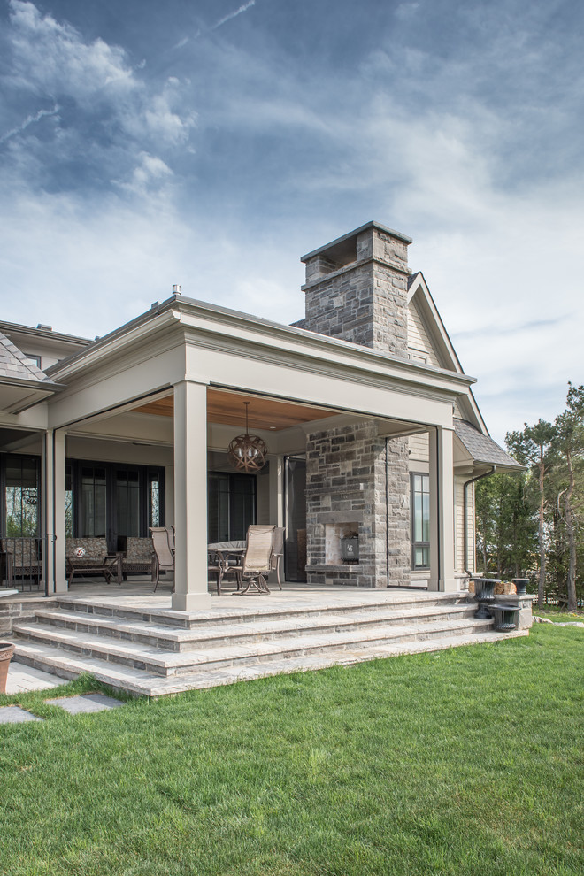 Idee per un portico classico di medie dimensioni e dietro casa con pavimentazioni in pietra naturale e un tetto a sbalzo