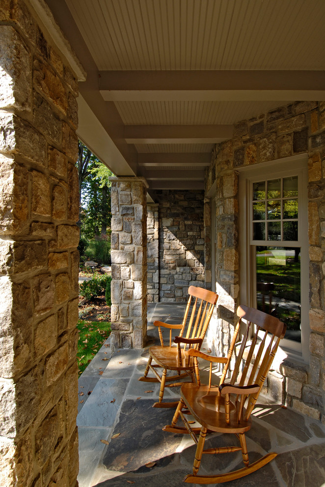 Ejemplo de terraza clásica en anexo de casas y patio delantero con adoquines de piedra natural