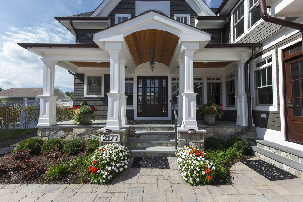 Ispirazione per un portico stile marinaro davanti casa e di medie dimensioni con pavimentazioni in pietra naturale e un tetto a sbalzo