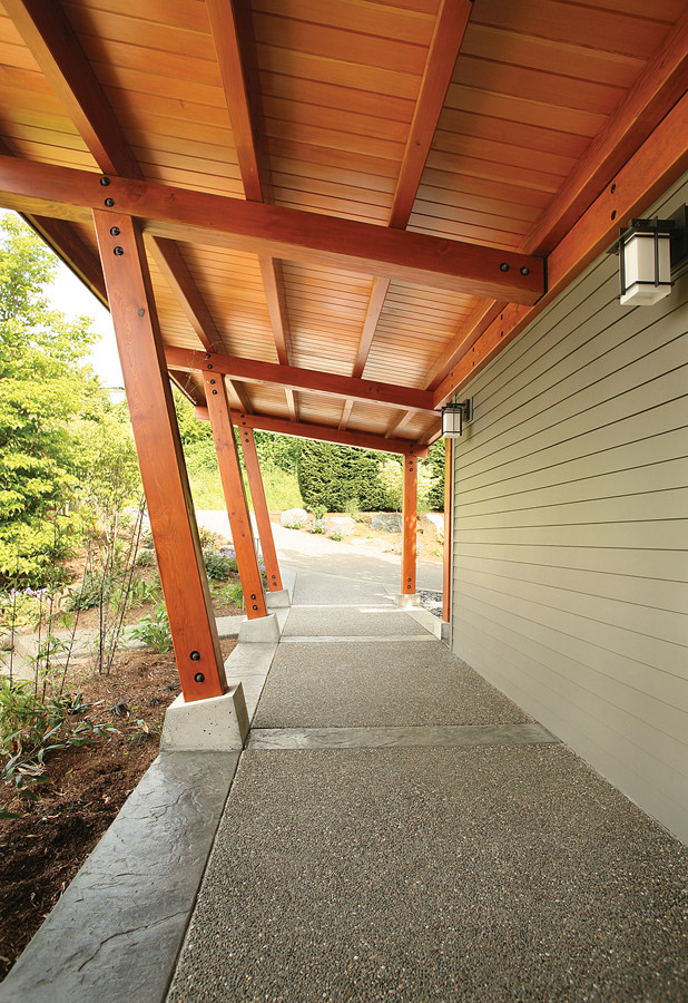 Immagine di un portico minimal nel cortile laterale e di medie dimensioni con cemento stampato e un tetto a sbalzo