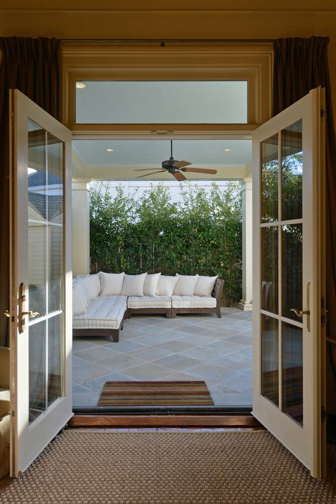 Cette photo montre un porche d'entrée de maison arrière chic de taille moyenne avec des pavés en pierre naturelle et une extension de toiture.