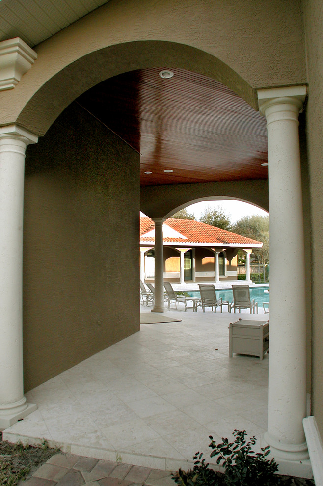 Imagen de terraza mediterránea grande en patio trasero y anexo de casas con adoquines de piedra natural