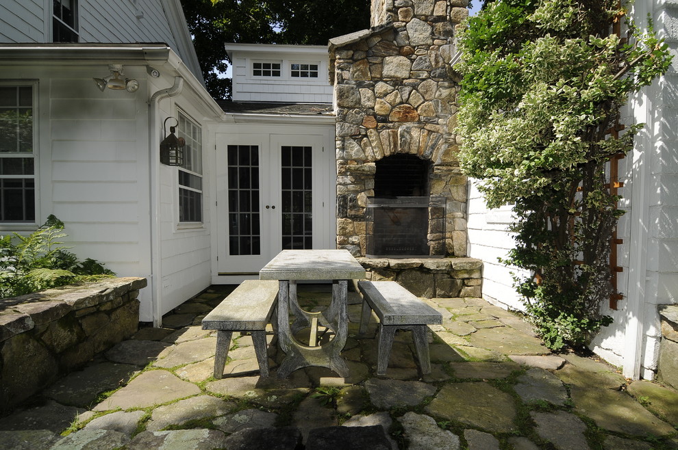 Cette image montre un porche d'entrée de maison avant rustique avec un foyer extérieur et des pavés en pierre naturelle.