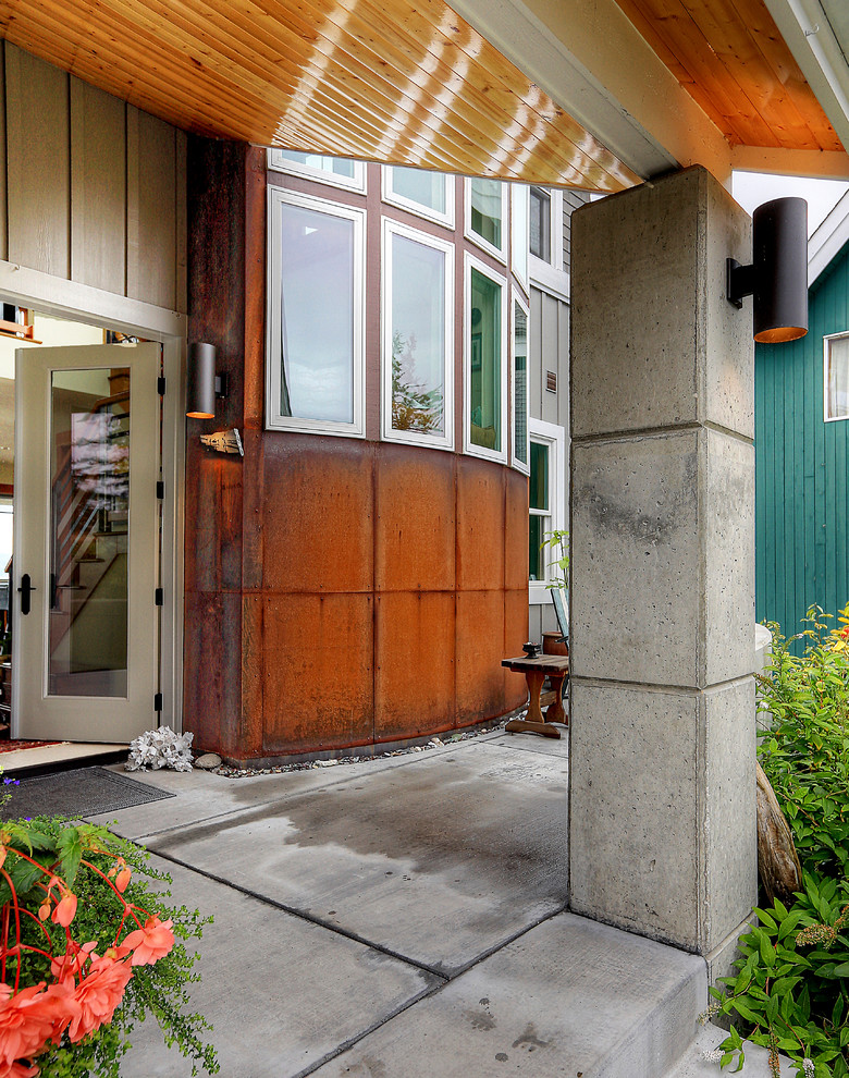 Idée de décoration pour un porche d'entrée de maison avant marin de taille moyenne avec des colonnes, une dalle de béton et une extension de toiture.