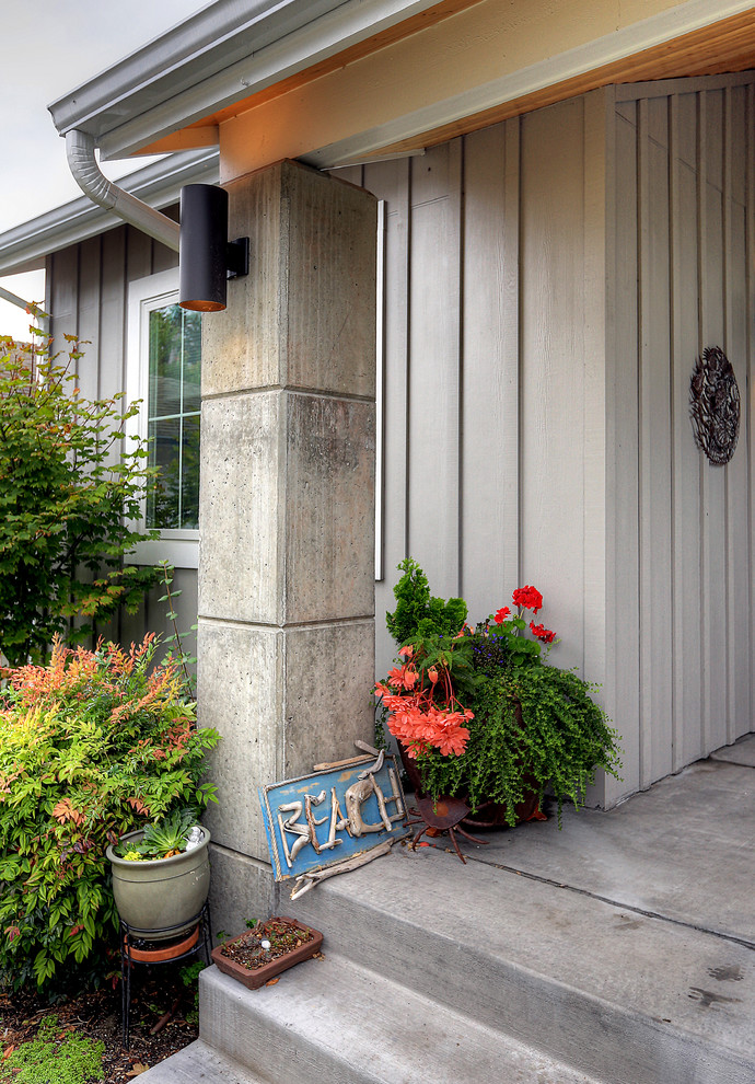 Mid-sized beach style concrete porch photo in Seattle with a roof extension