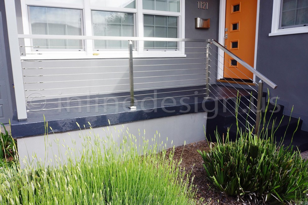 Ejemplo de terraza de estilo americano pequeña en patio delantero con adoquines de hormigón y toldo