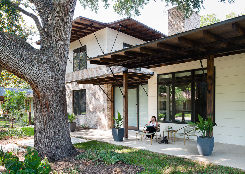 Idées déco pour un porche d'entrée de maison contemporain avec une dalle de béton et une extension de toiture.