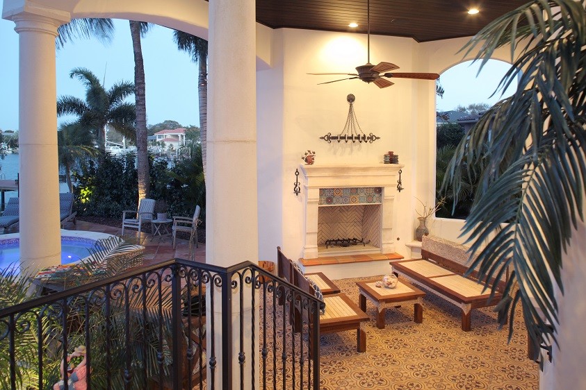 Photo of an expansive mediterranean back veranda in Tampa with tiled flooring and a roof extension.