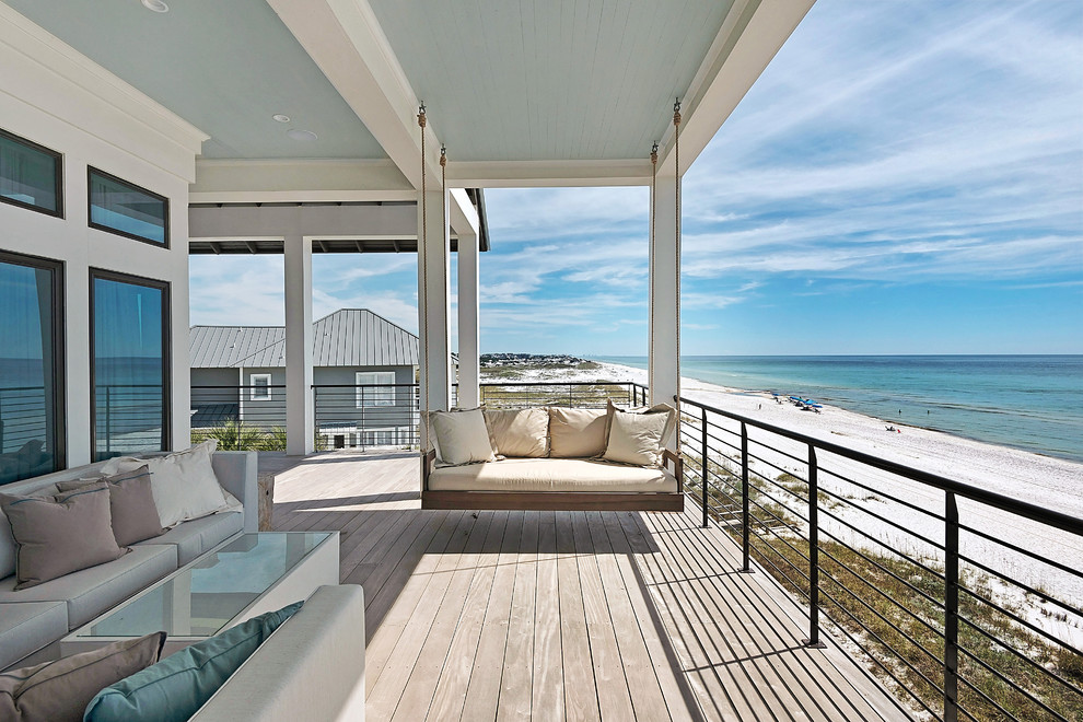 Idées déco pour un grand porche d'entrée de maison arrière bord de mer avec une terrasse en bois et une extension de toiture.