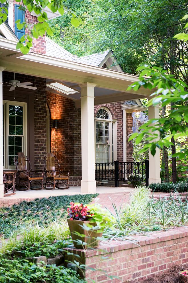 Inspiration for a mid-sized timeless brick front porch remodel in Atlanta with a roof extension