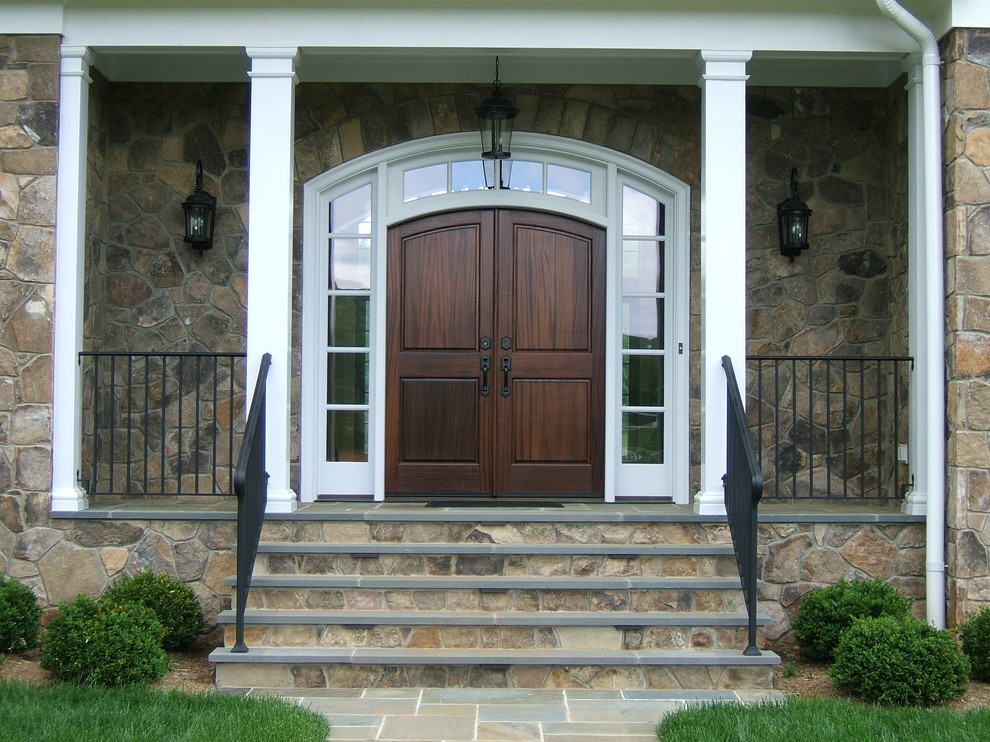 Foto di un portico tradizionale di medie dimensioni e davanti casa con un tetto a sbalzo e pavimentazioni in pietra naturale