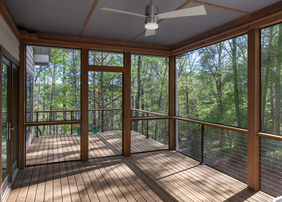 Idée de décoration pour un porche d'entrée de maison latéral design de taille moyenne avec une moustiquaire, une terrasse en bois et une extension de toiture.