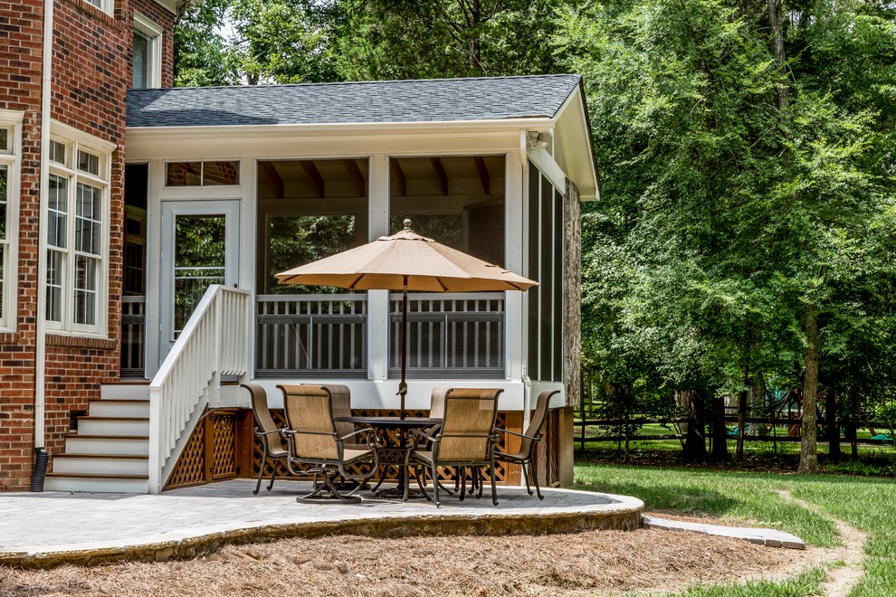 Large elegant side yard deck photo in Charlotte with a roof extension