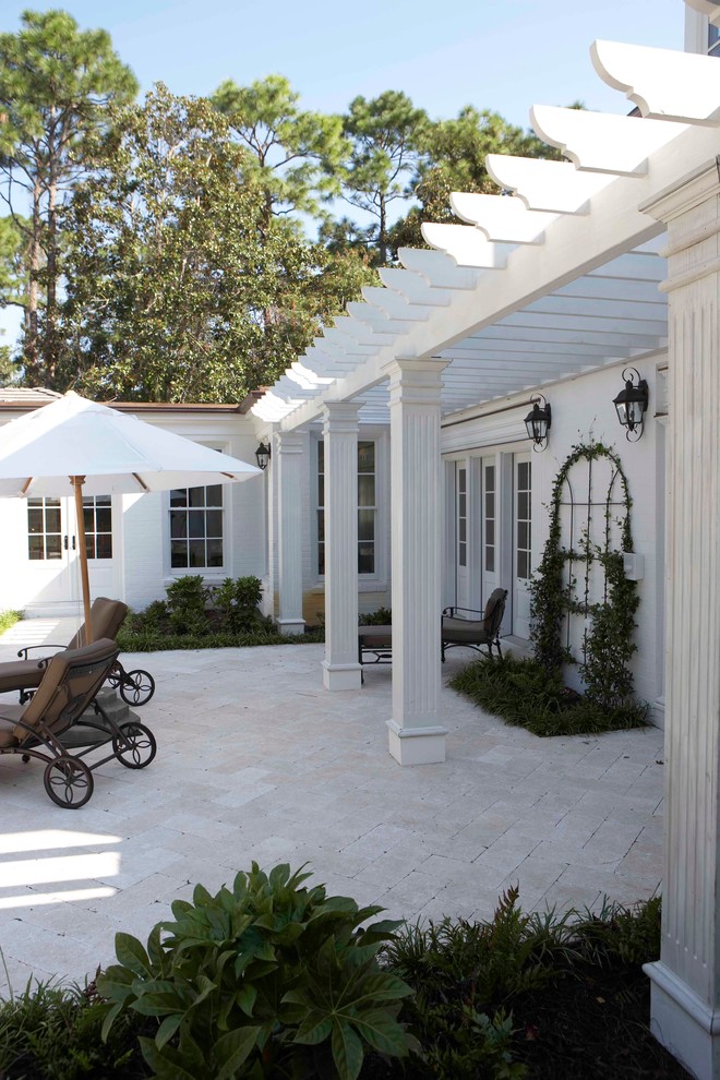 Large elegant stone back porch photo in Wilmington with a pergola