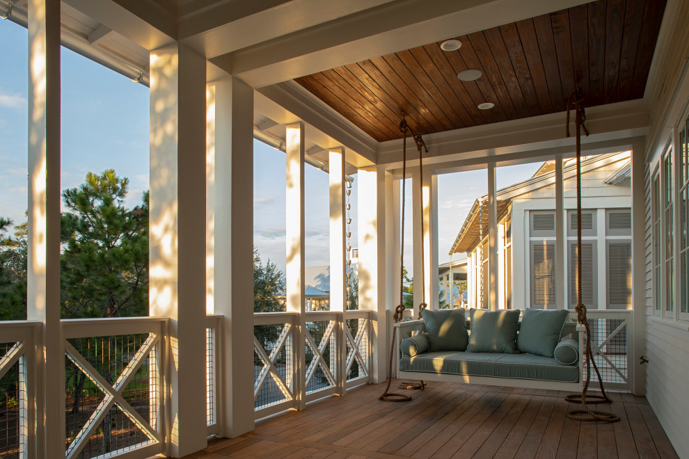 Idée de décoration pour un grand porche d'entrée de maison avant marin avec une terrasse en bois et une extension de toiture.