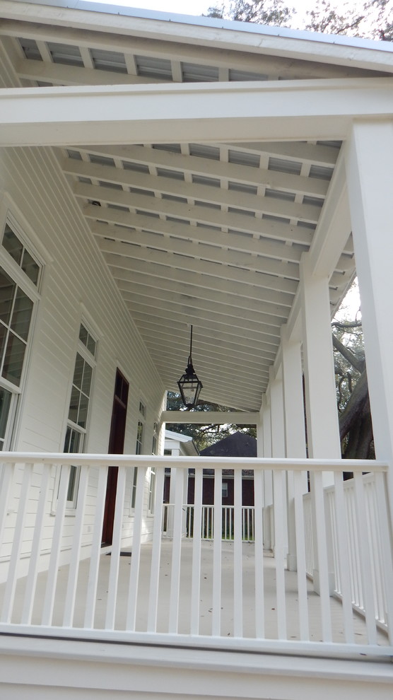 Bild på en mellanstor lantlig veranda framför huset, med takförlängning