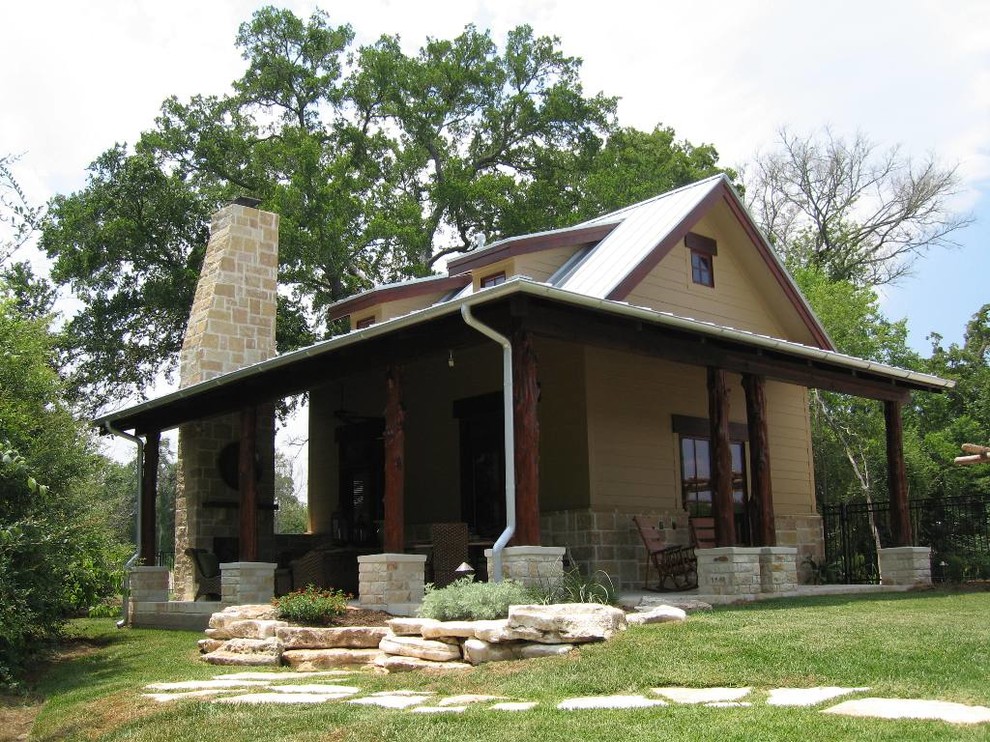 Diseño de terraza de estilo de casa de campo en patio trasero y anexo de casas con cocina exterior y adoquines de piedra natural