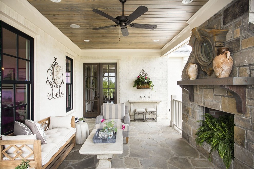 Mid-sized classic stone back porch idea in Little Rock with a fire pit and a roof extension