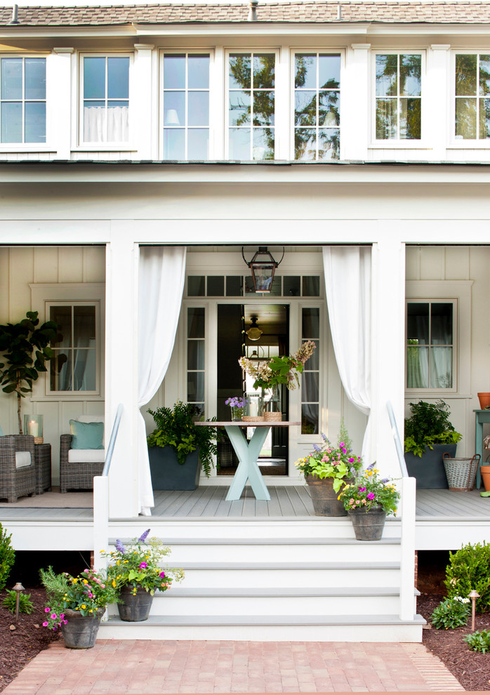 Réalisation d'un porche d'entrée de maison tradition avec une terrasse en bois et une extension de toiture.